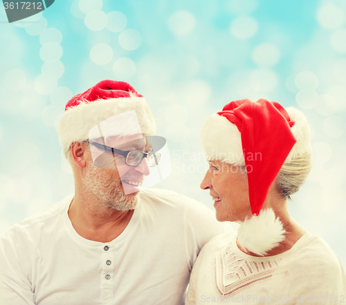 Image of happy senior couple in santa helper hats