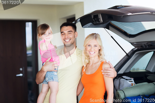 Image of happy family with hatchback car at home parking