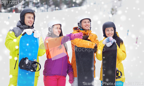 Image of happy friends in helmets with snowboards