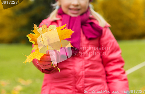 Image of close up of happy girl with autumnn maple leaves