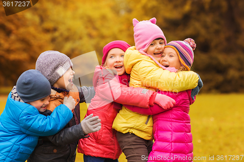 Image of group of happy children hugging in autumn park