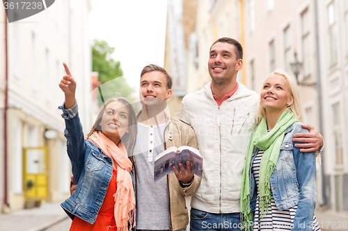 Image of group of friends with city guide exploring town