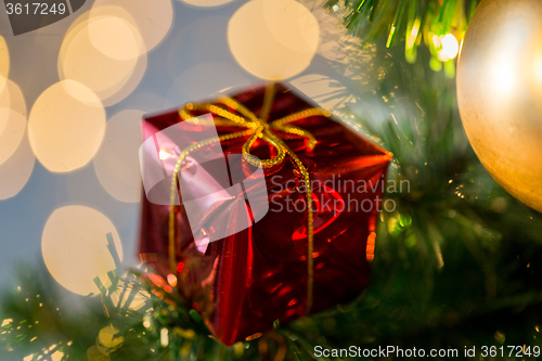 Image of close up of gift box decoration on christmas tree