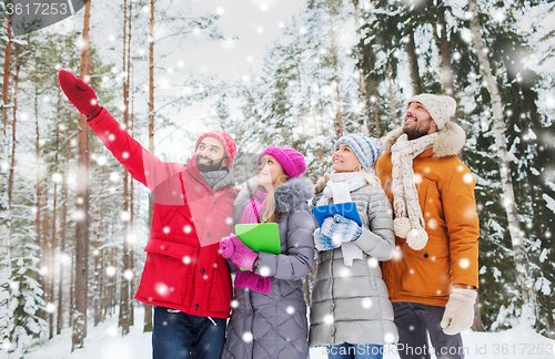 Image of smiling friends with tablet pc in winter forest