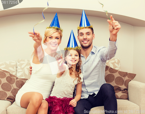 Image of smiling family in blue hats with cake