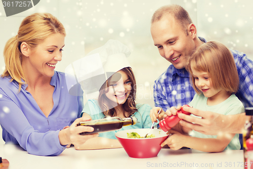 Image of happy family with two kids making salad at home