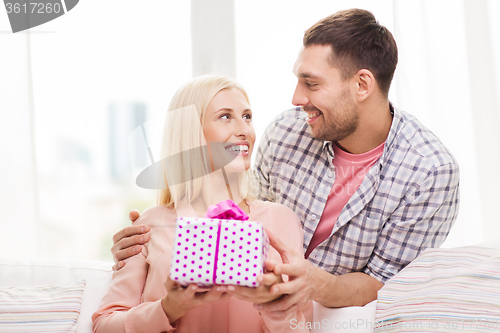 Image of happy man giving woman gift box at home