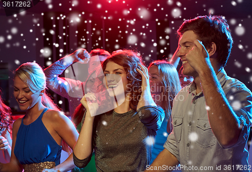 Image of group of happy friends dancing in night club