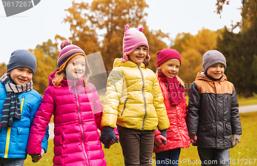 Image of happy children holding hands in autumn park