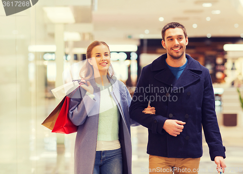 Image of happy young couple with shopping bags in mall