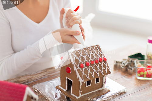 Image of close up of woman making gingerbread house at home