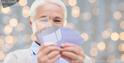 Image of close up of happy senior woman playing cards