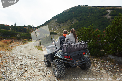 Image of couple drive atv quad bike