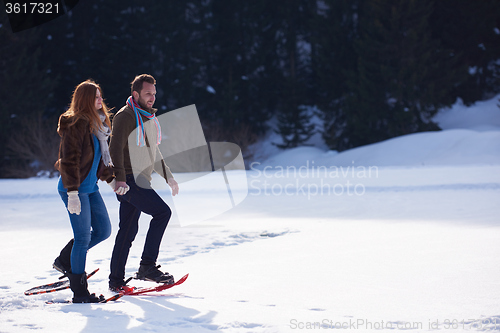 Image of couple having fun and walking in snow shoes