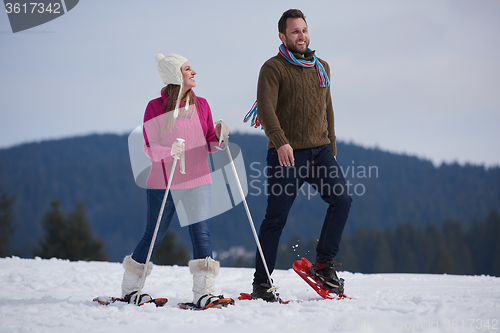 Image of couple having fun and walking in snow shoes