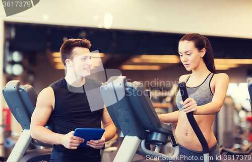 Image of woman with trainer exercising on stepper in gym