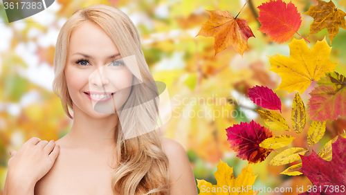 Image of beautiful young woman face over autumn leaves