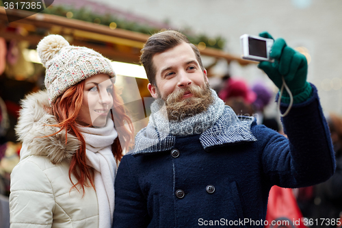 Image of couple taking selfie with smartphone in old town