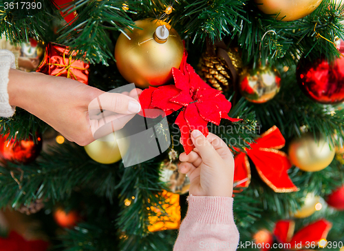 Image of close up of family decorating christmas tree