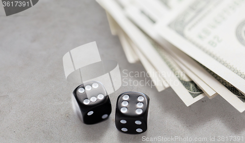 Image of close up of black dice and dollar cash money