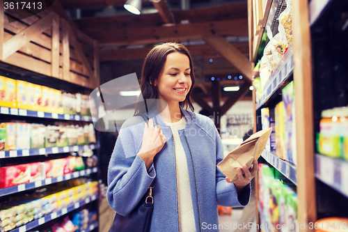 Image of happy woman choosing and buying food in market