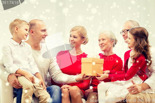 Image of smiling family with gift at home