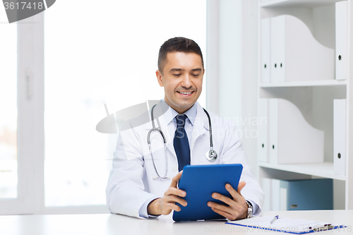 Image of smiling male doctor in white coat with tablet pc