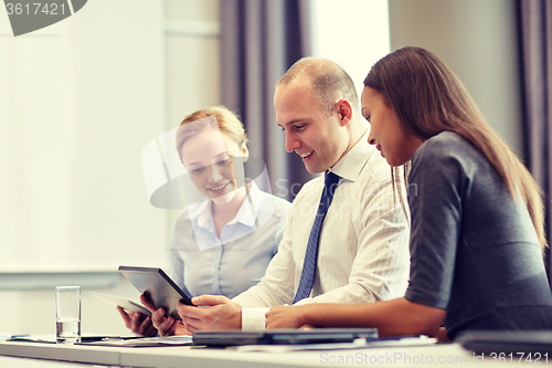 Image of smiling business people with tablet pc in office