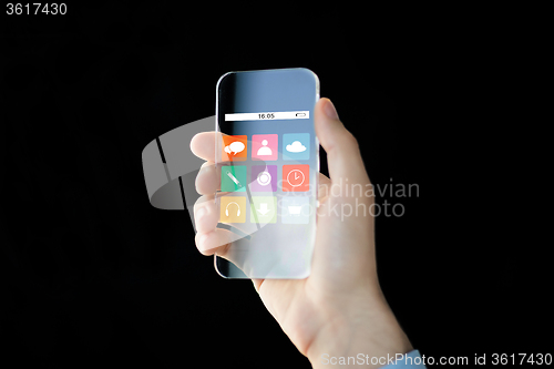 Image of close up of male hand with transparent smartphone