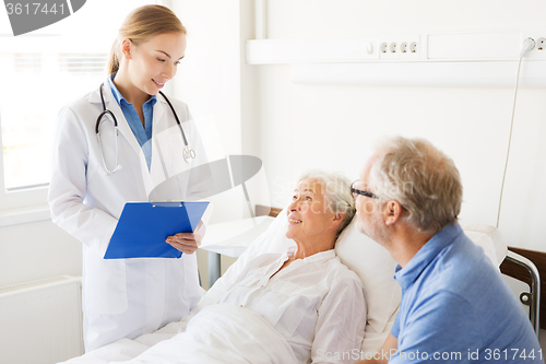 Image of senior woman and doctor with clipboard at hospital