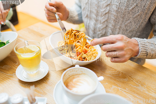 Image of close up man eating pasta for dinner at restaurant