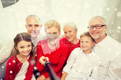 Image of smiling family with selfie stick photographing