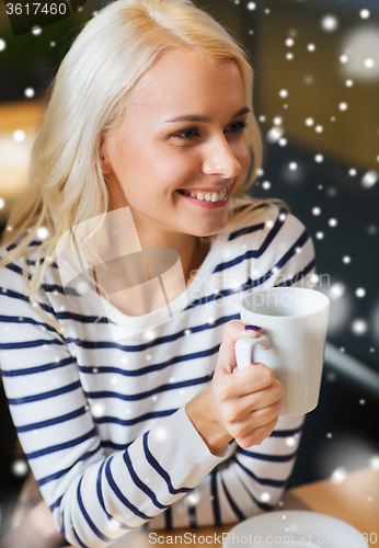 Image of happy young woman drinking tea or coffee