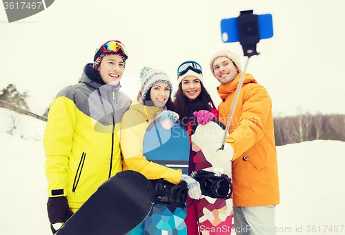 Image of happy friends with snowboards and smartphone