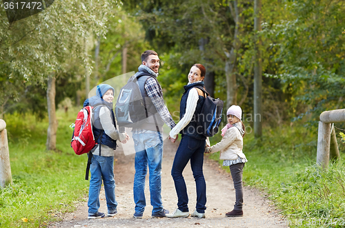 Image of happy family with backpacks hiking walking