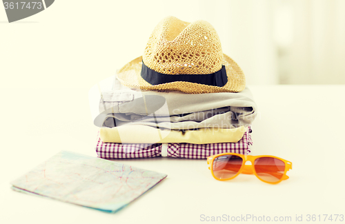 Image of close up of summer clothes and travel map on table