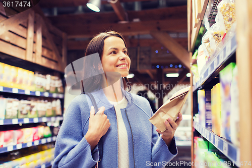 Image of happy woman choosing and buying food in market