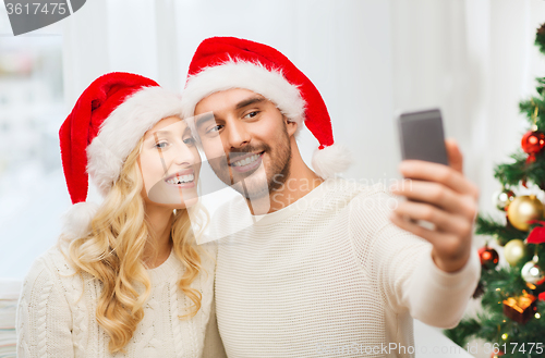 Image of couple taking selfie with smartphone at christmas