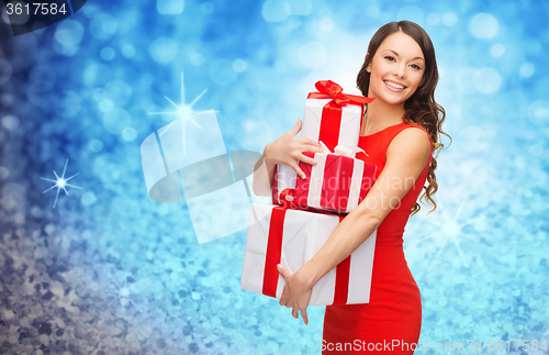 Image of smiling woman in red dress with many gift boxes