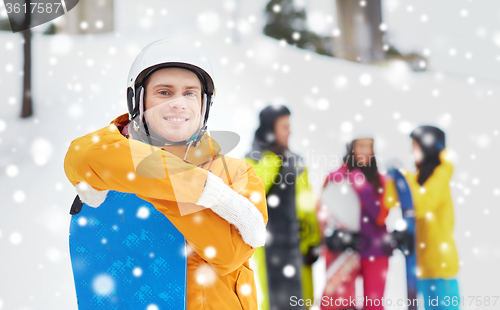 Image of happy friends in helmets with snowboards