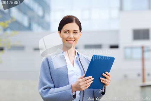Image of smiling business woman with tablet pc in city