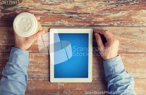 Image of close up of male hands with tablet pc and coffee