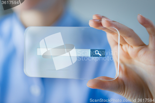 Image of close up of woman with transparent smartphone