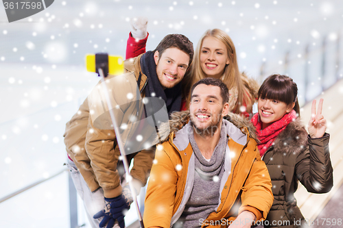 Image of happy friends with smartphone on skating rink