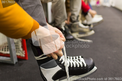 Image of close up of friends wearing skates on skating rink