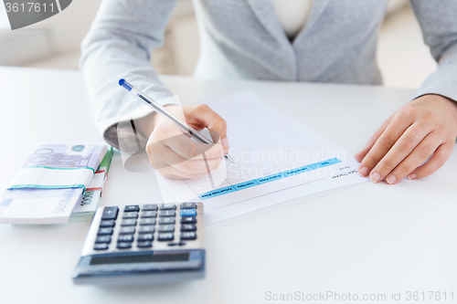 Image of close up of hands counting money with calculator