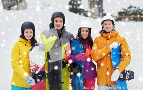 Image of happy friends in helmets with snowboards