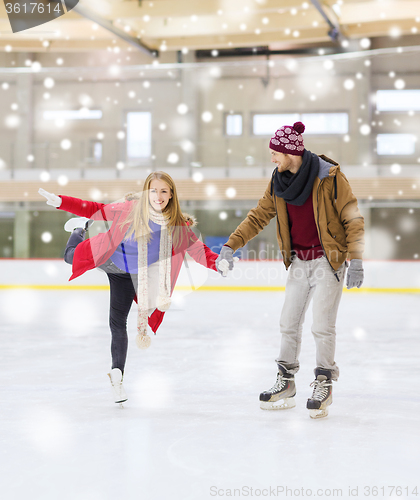 Image of happy couple holding hands on skating rink