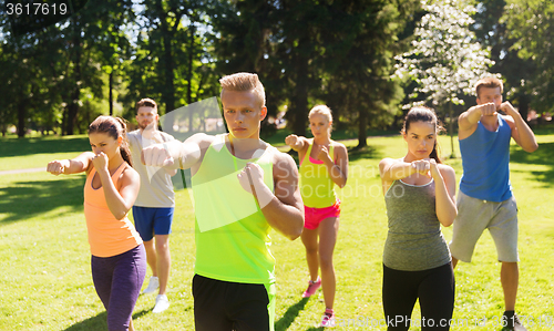 Image of group of friends or sportsmen exercising outdoors