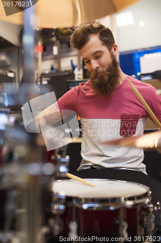 Image of male musician playing cymbals at music store